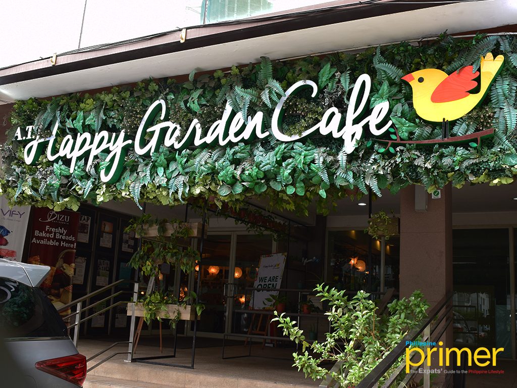 Happy Garden Cafe exterior storefront with green signage and lush plants on Jupiter Street, Makati